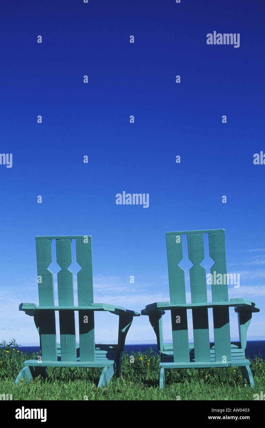 Green wooden lawn chairs sit on lawn by oceanside vista Stock Photo - Alamy