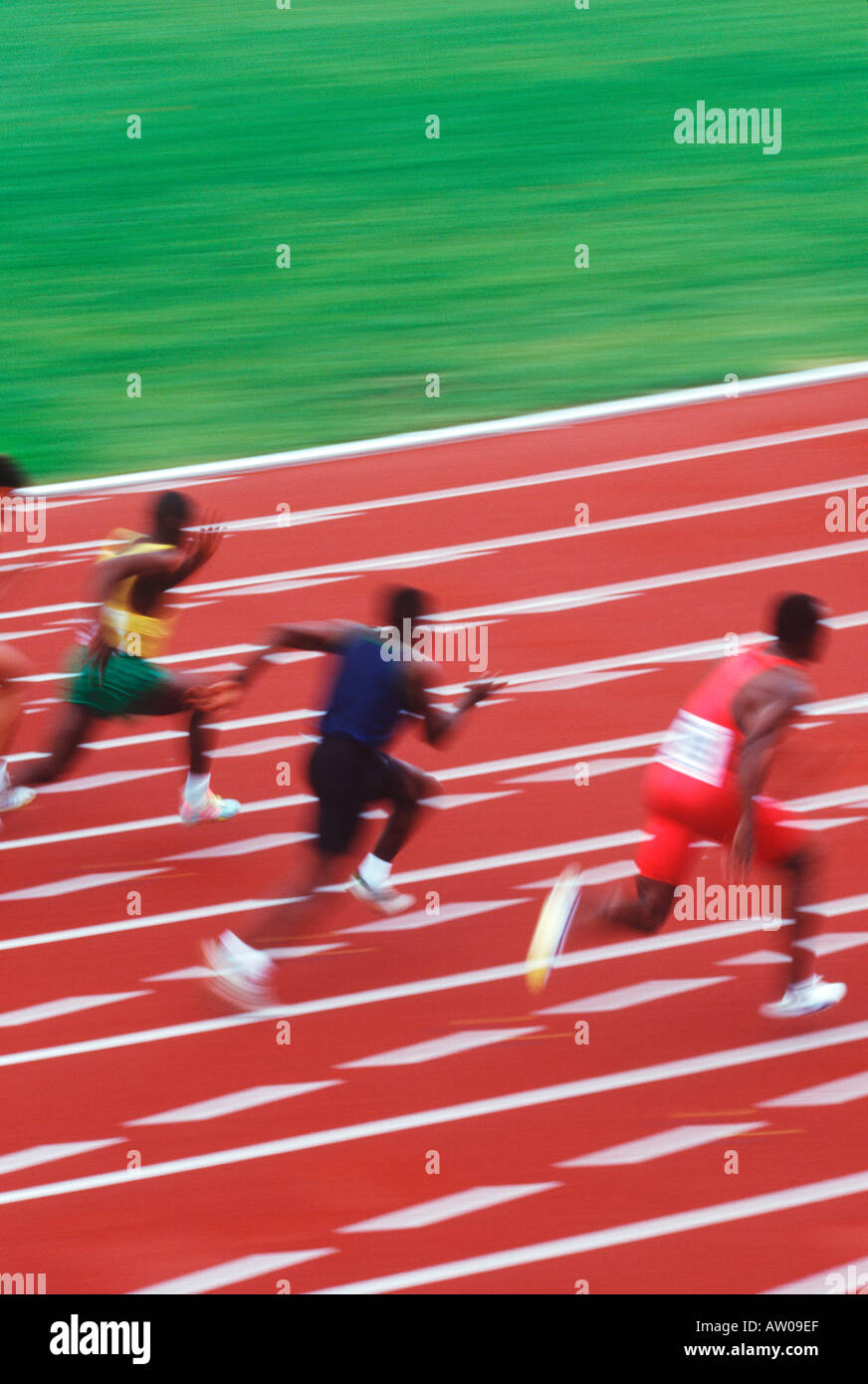 Track and field competition sprinters on rust coloured track Stock