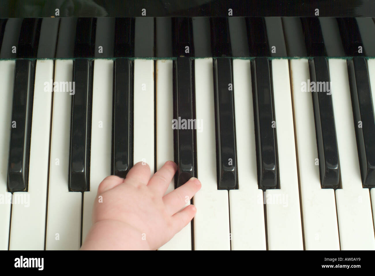 close up of baby s hand playing piano Stock Photo