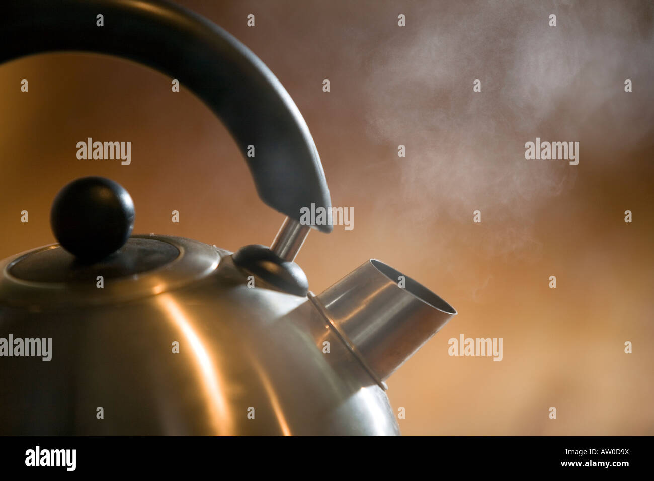 a stainless steel kettle is boiling water to produce steam Stock Photo