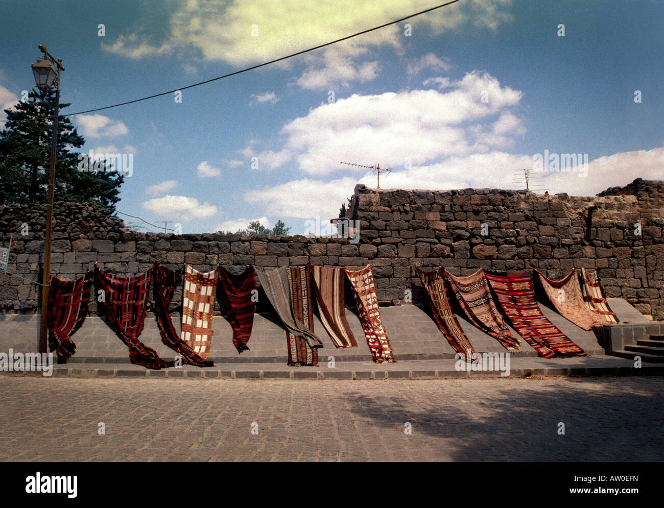 Carpets drying in the hot desert sun in Bosra, Syria Stock Photo