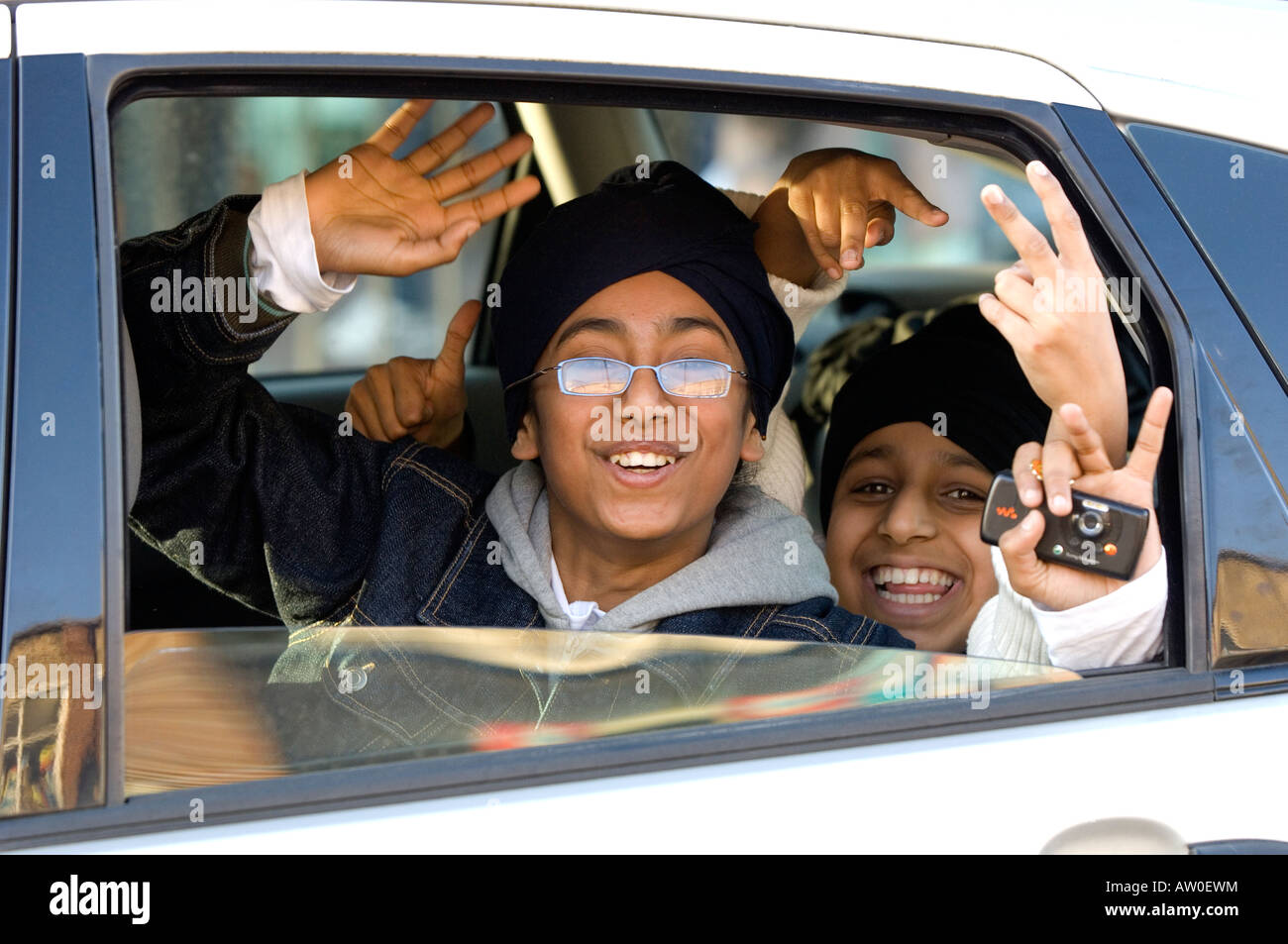 Sikh children messing about in a car Southall London United Kingdom Stock Photo