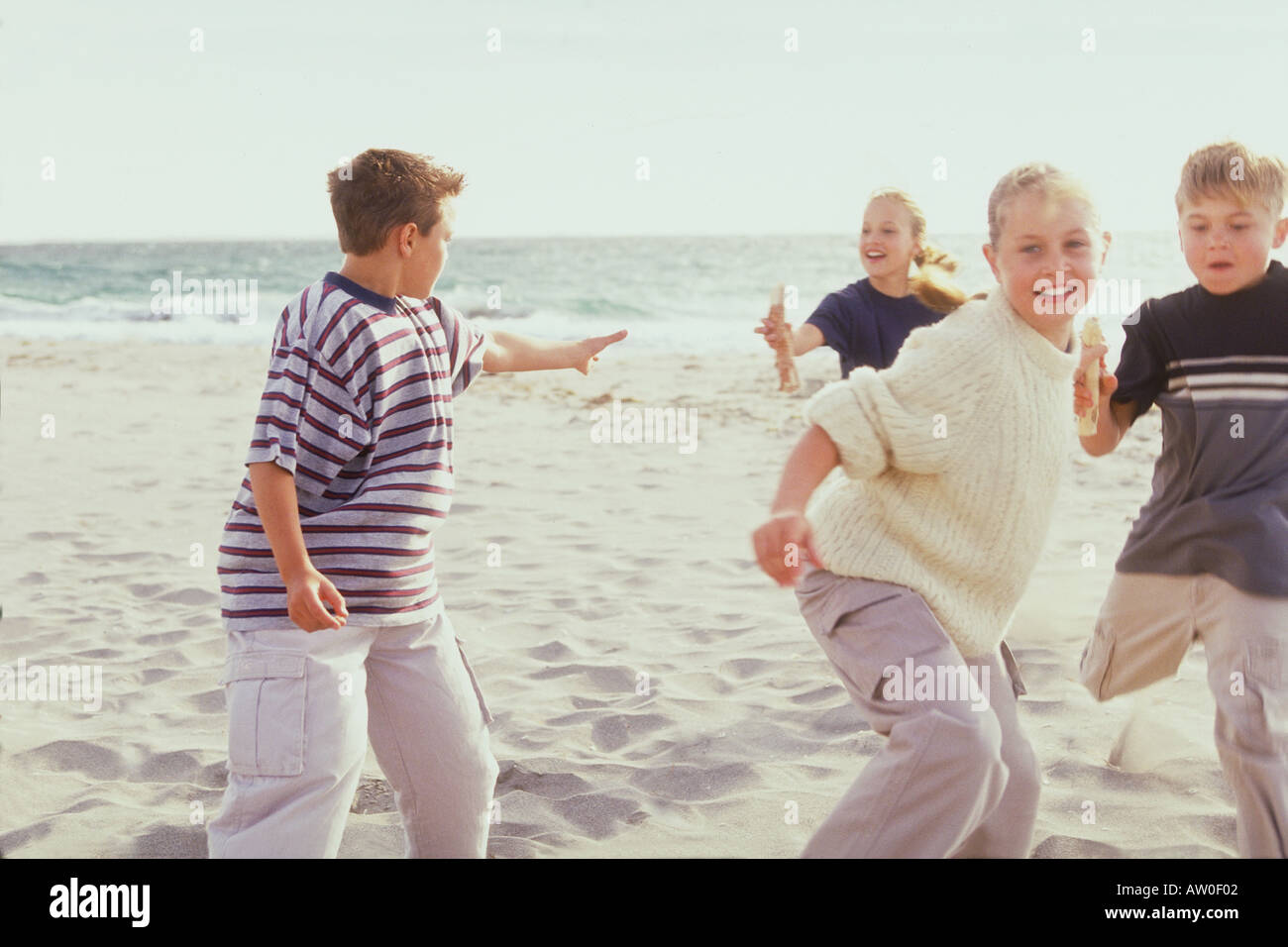 portrait of a group of kids having changeover in relay race at the beach Stock Photo