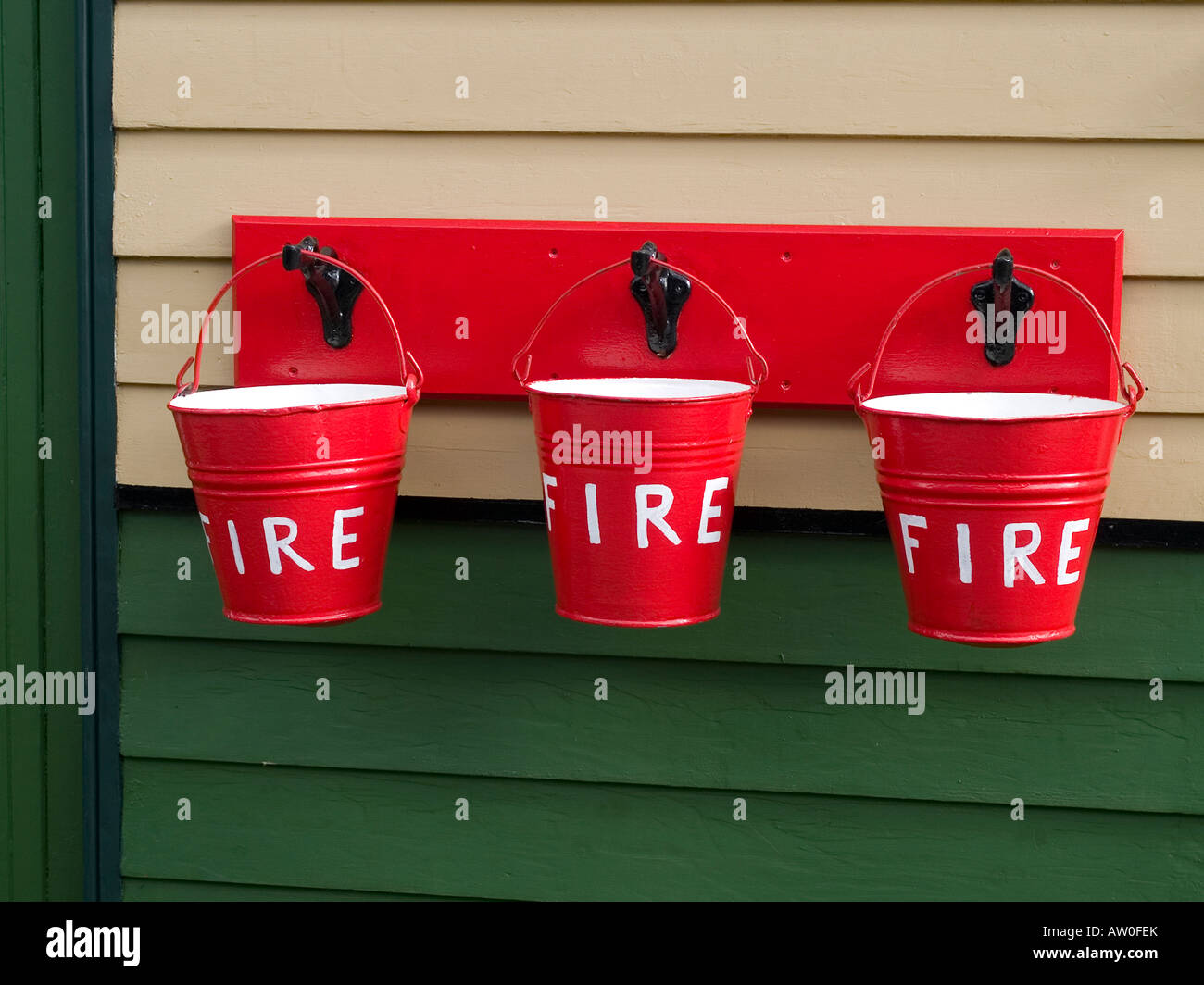 Three brightly painted fire buckets a traditional safety measure at Pickering Station North Yorkshire Moors Railway Stock Photo