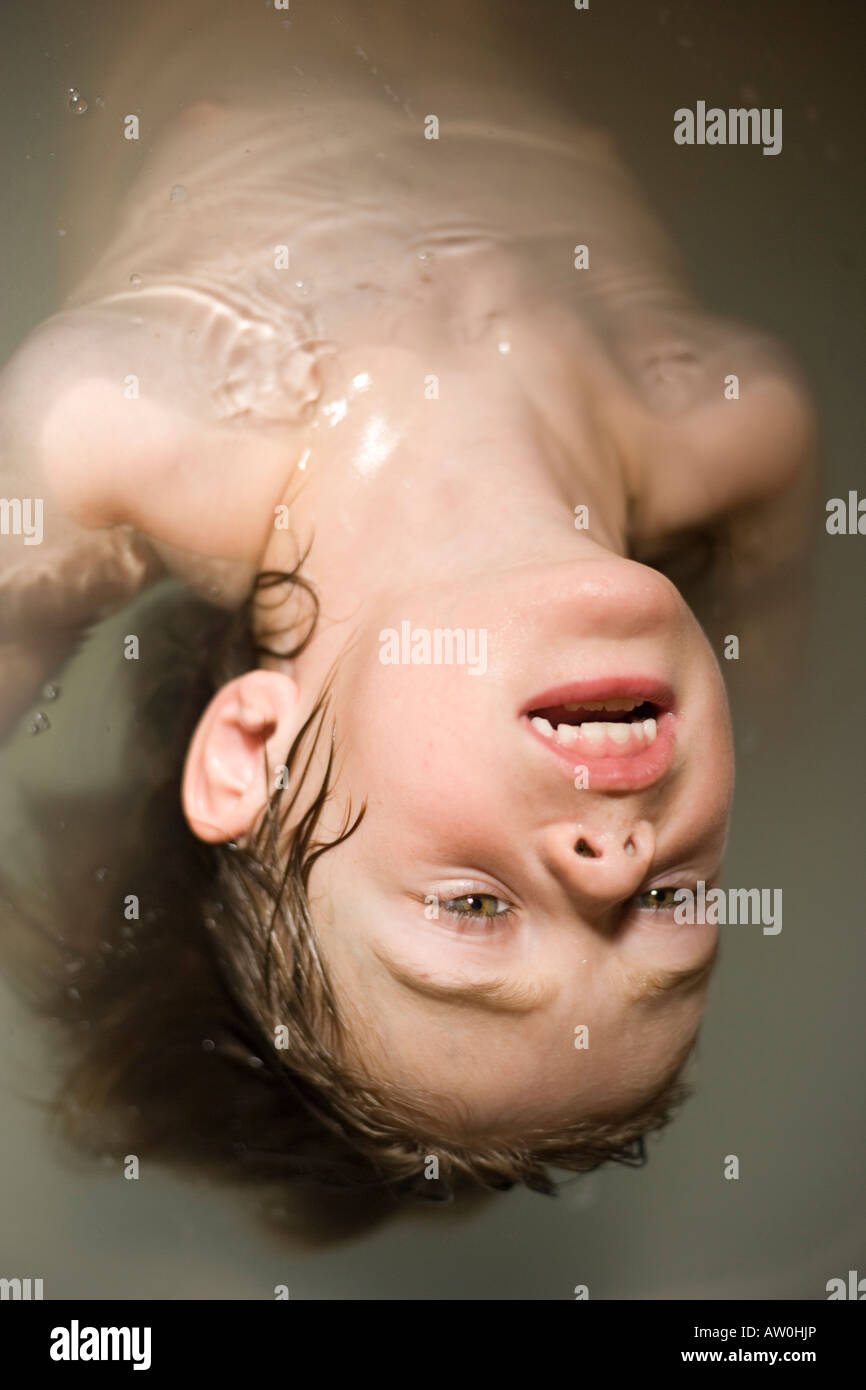 five year old child washing hair in bathtub, water rinse ...