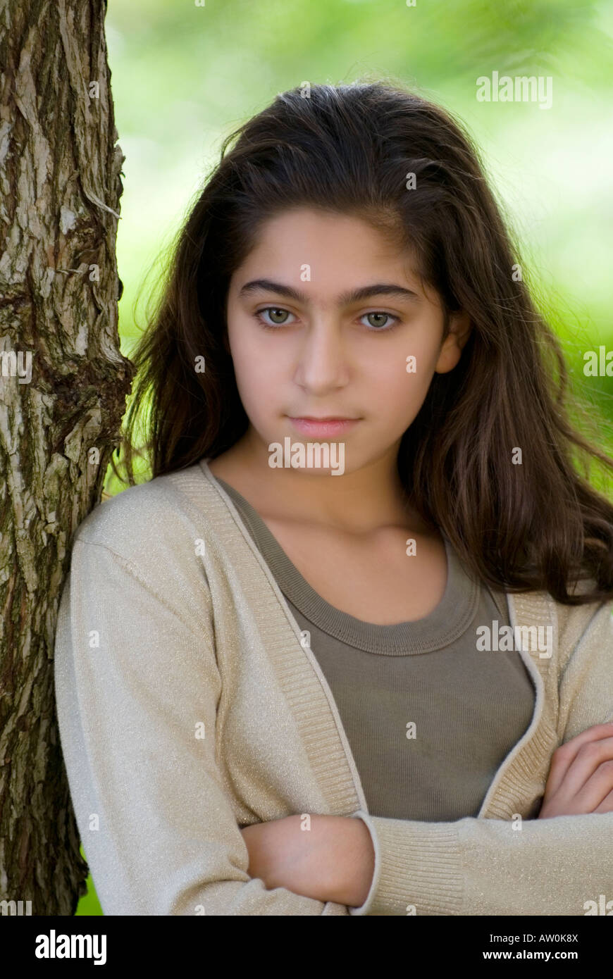 Serious 11 years old girl arms folded looking down Stock Photo