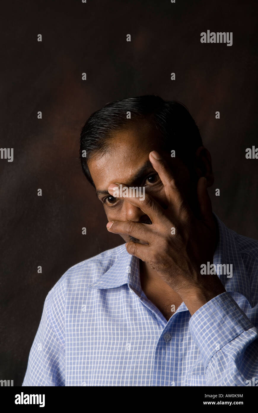 Indian man hiding face Stock Photo