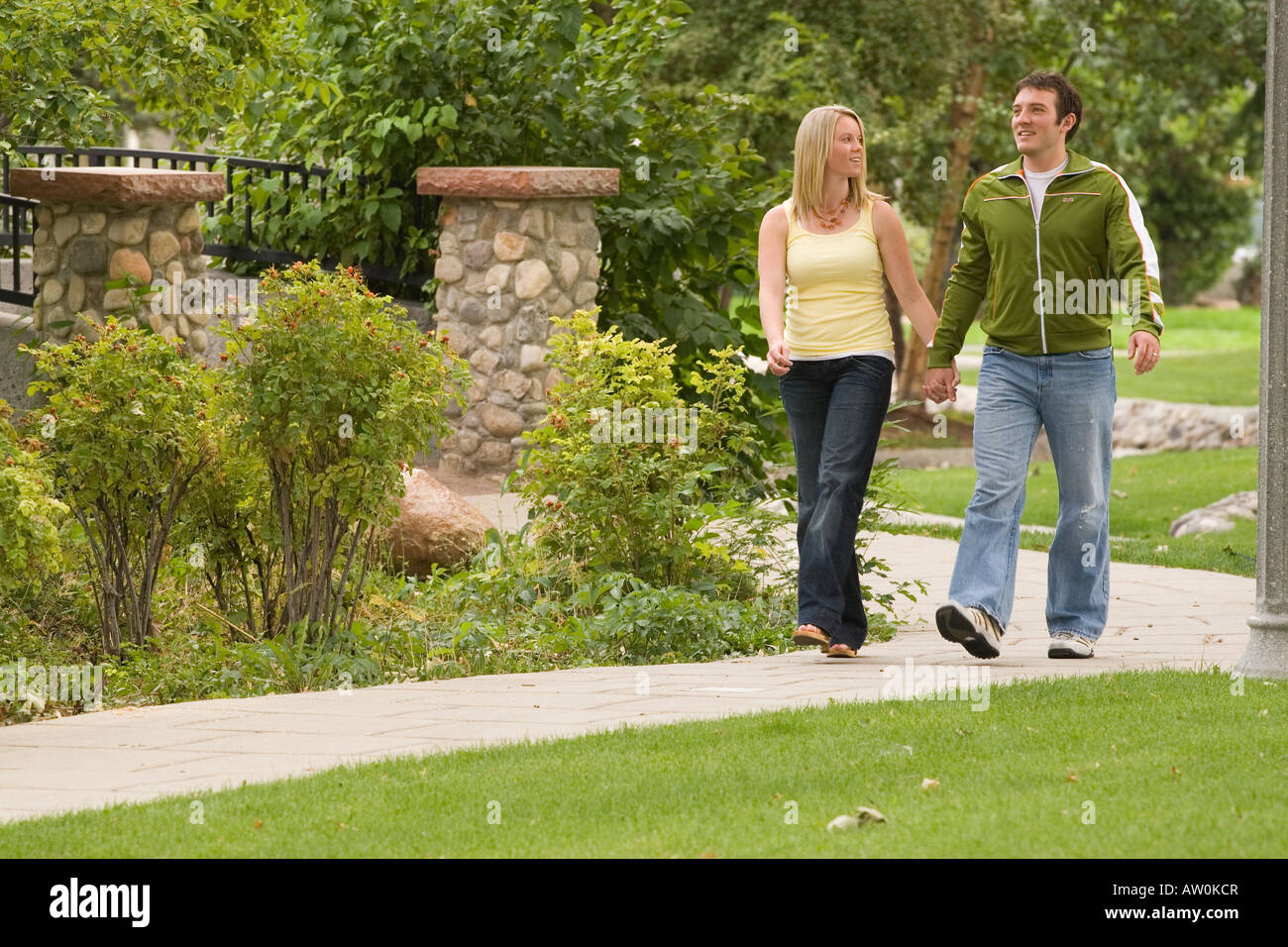Young couple enjoying a walk in the park Stock Photo - Alamy