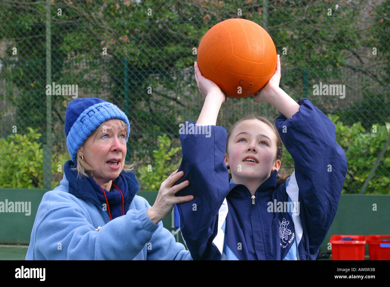 Teacher and pupil netball shooting Stock Photo