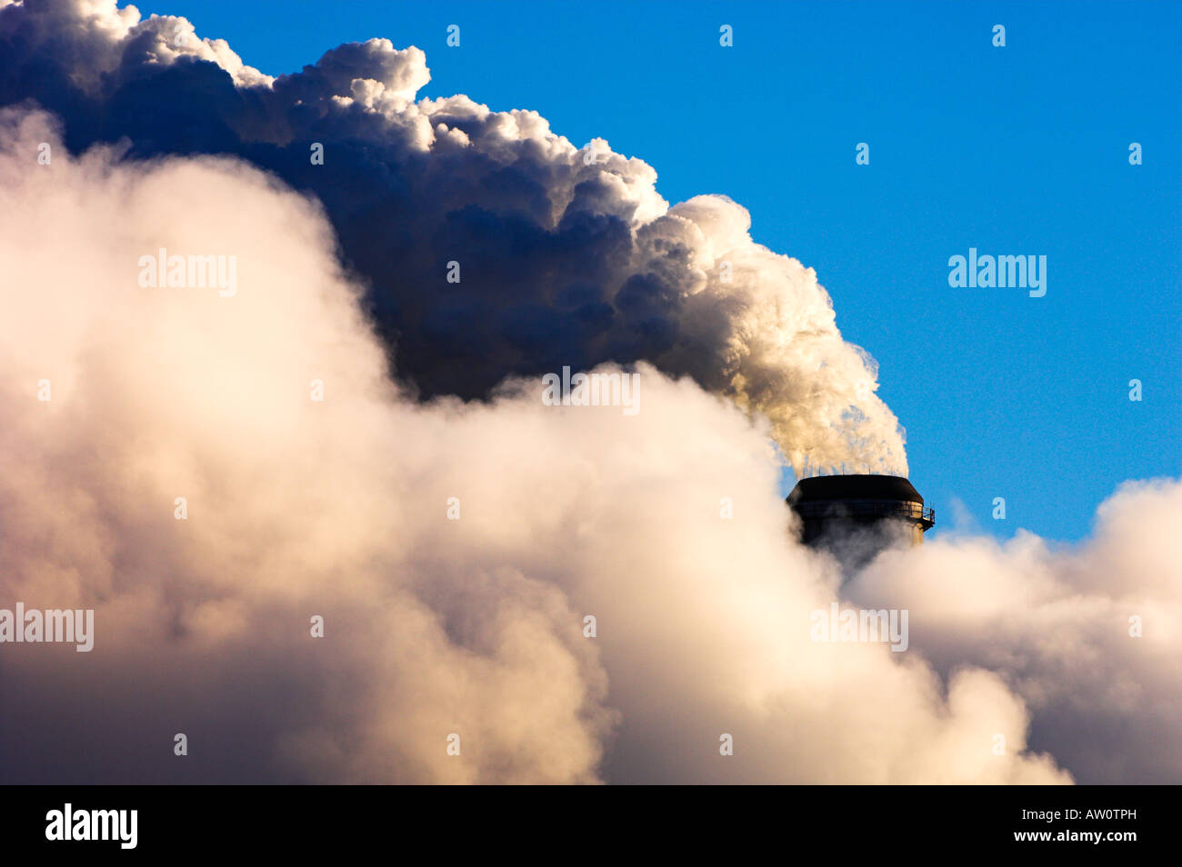 Steam rising from stack and cooling towers at nuclear power plant on cold morning Stock Photo