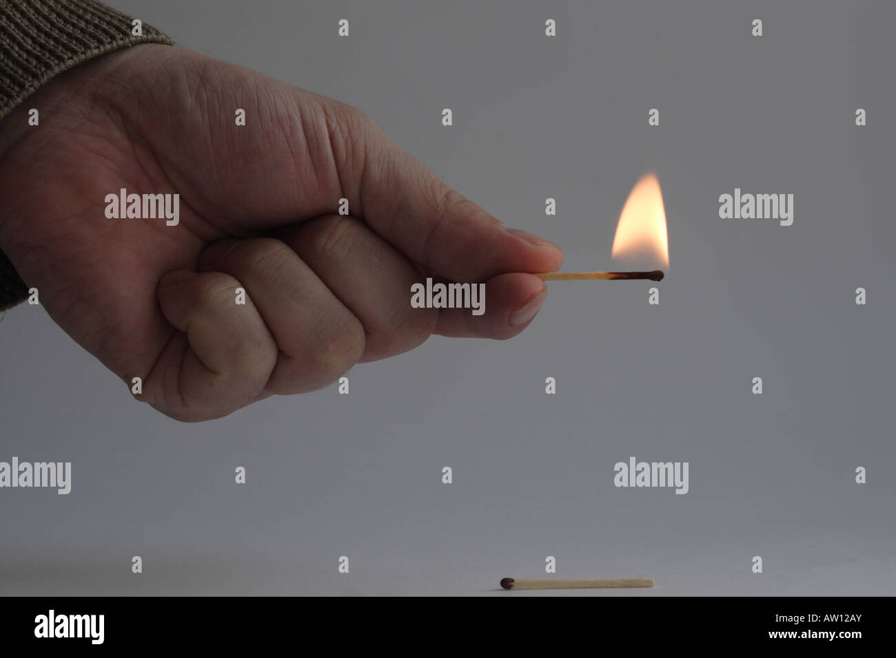 Hand with burning match Stock Photo