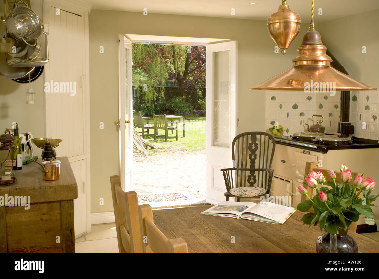 Home interior, traditional kitchen with Aga and open french doors. Stock Photo