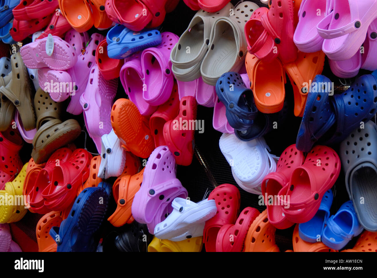 A large number of different colour crocs shoes sandals hanging on a street  vendors stall Lightweight resin material Stock Photo - Alamy