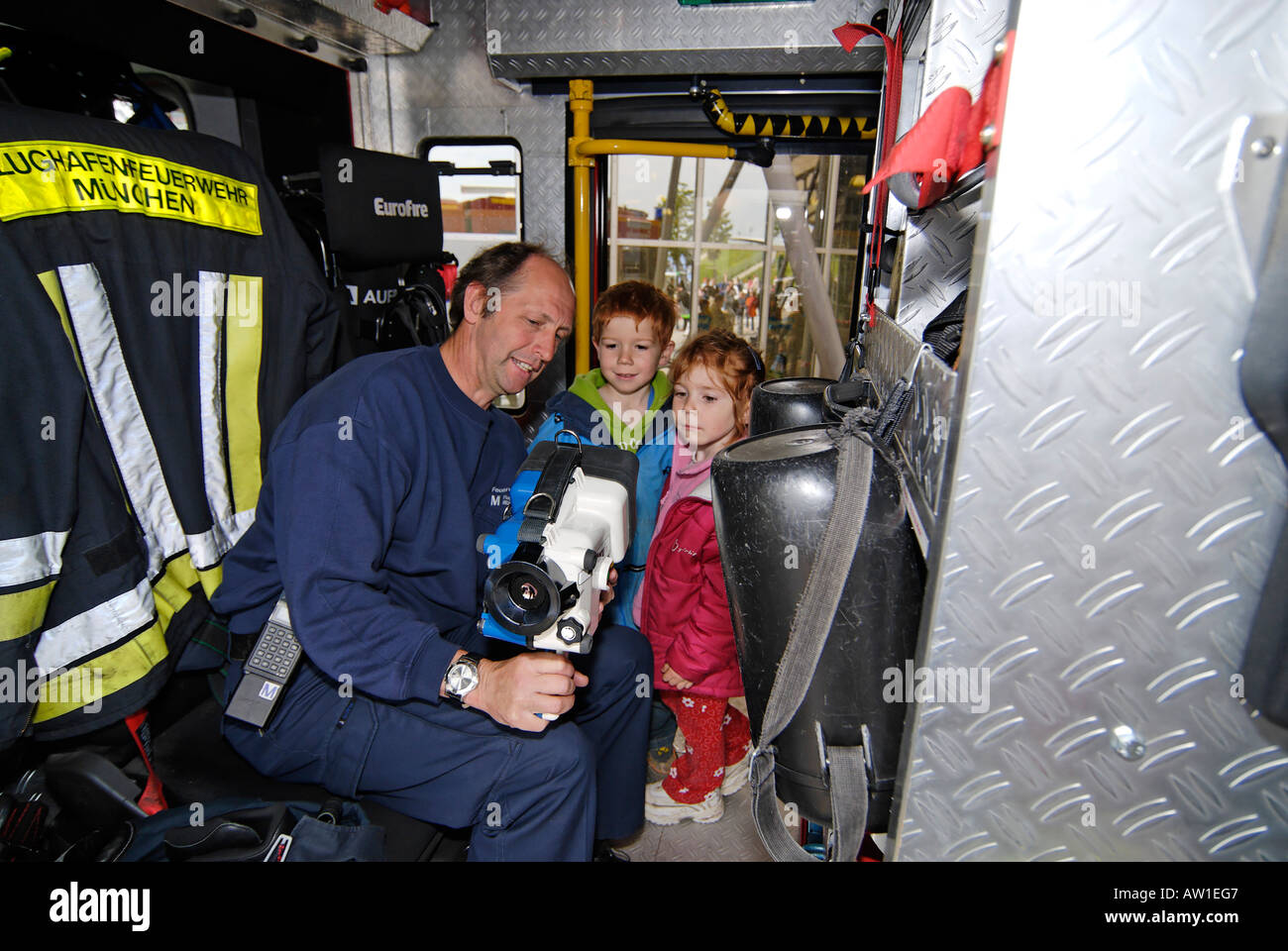 A Fireman explains a heat searching instrument to children Stock Photo