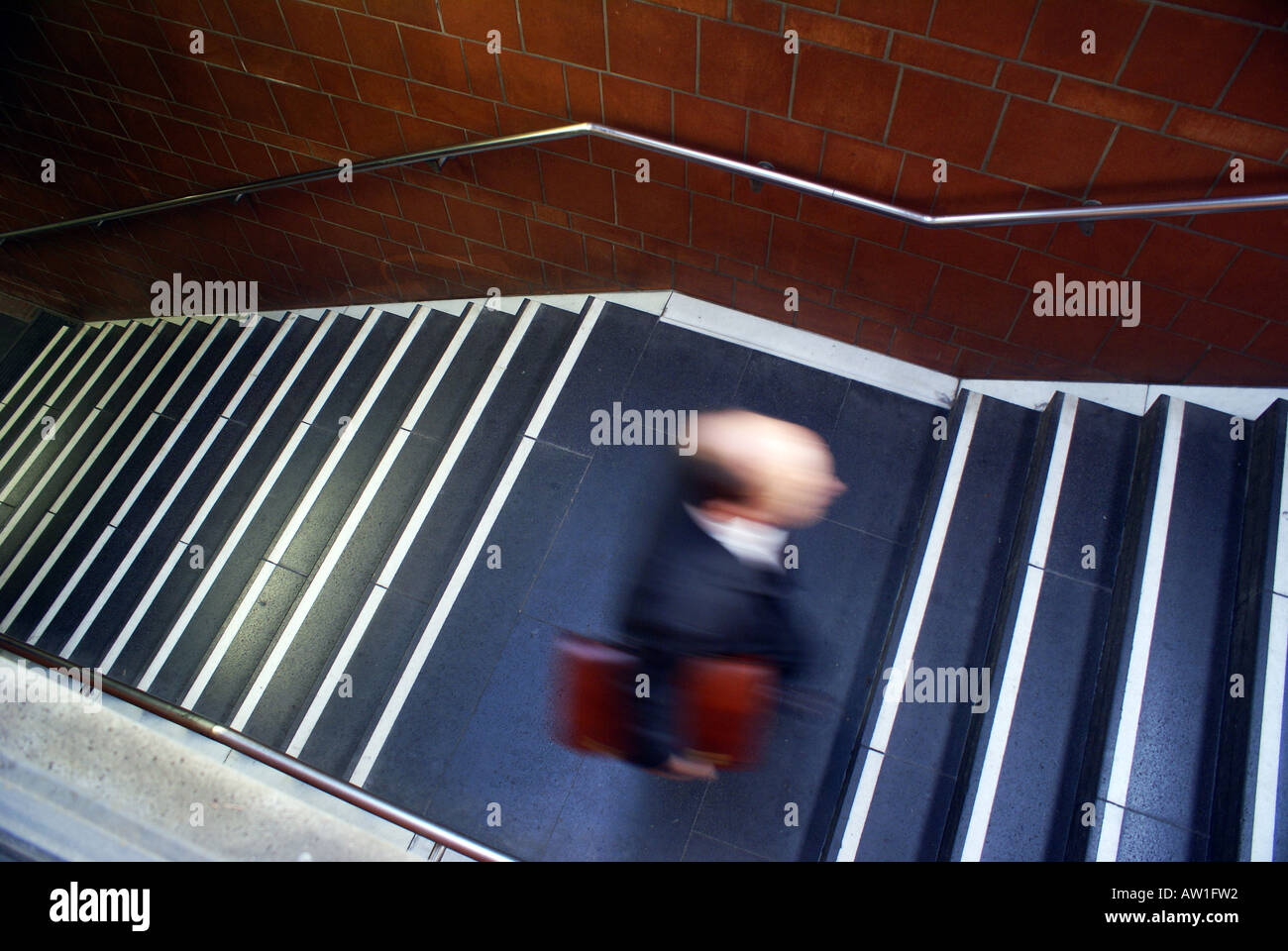 Man with bald head and briefcase going up in a staircase, Hauptbahnhof Bonn, NRW, Deutschland Stock Photo