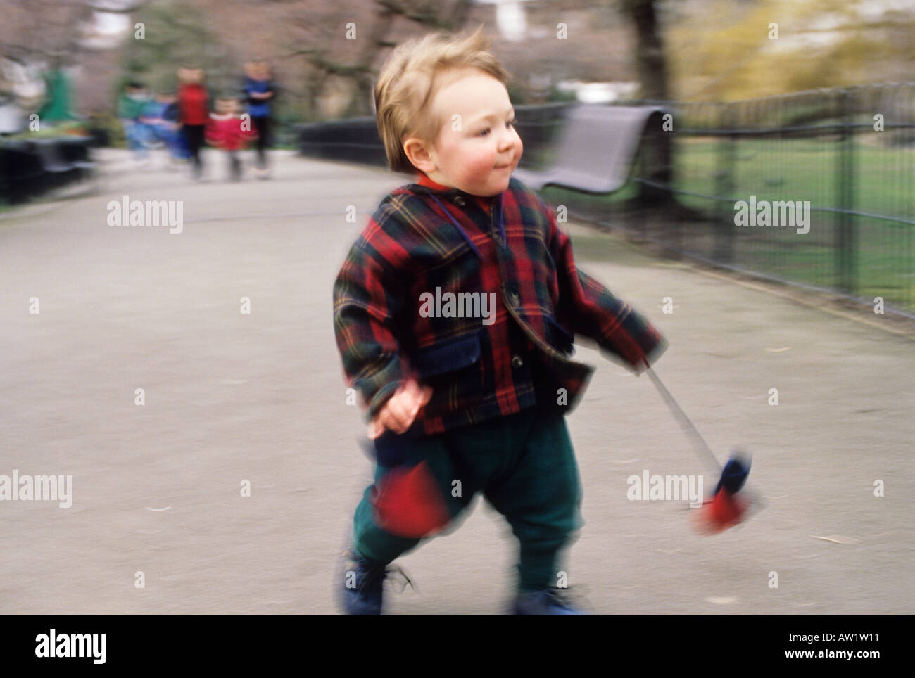 Two year old toddler boy running in park Stock Photo