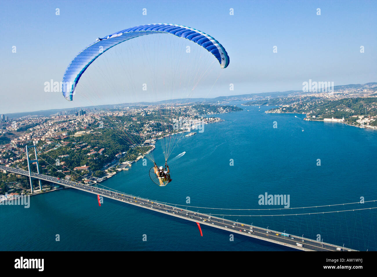 Powered paraglider flying over the Bosphorus Bridge aerial Istanbul