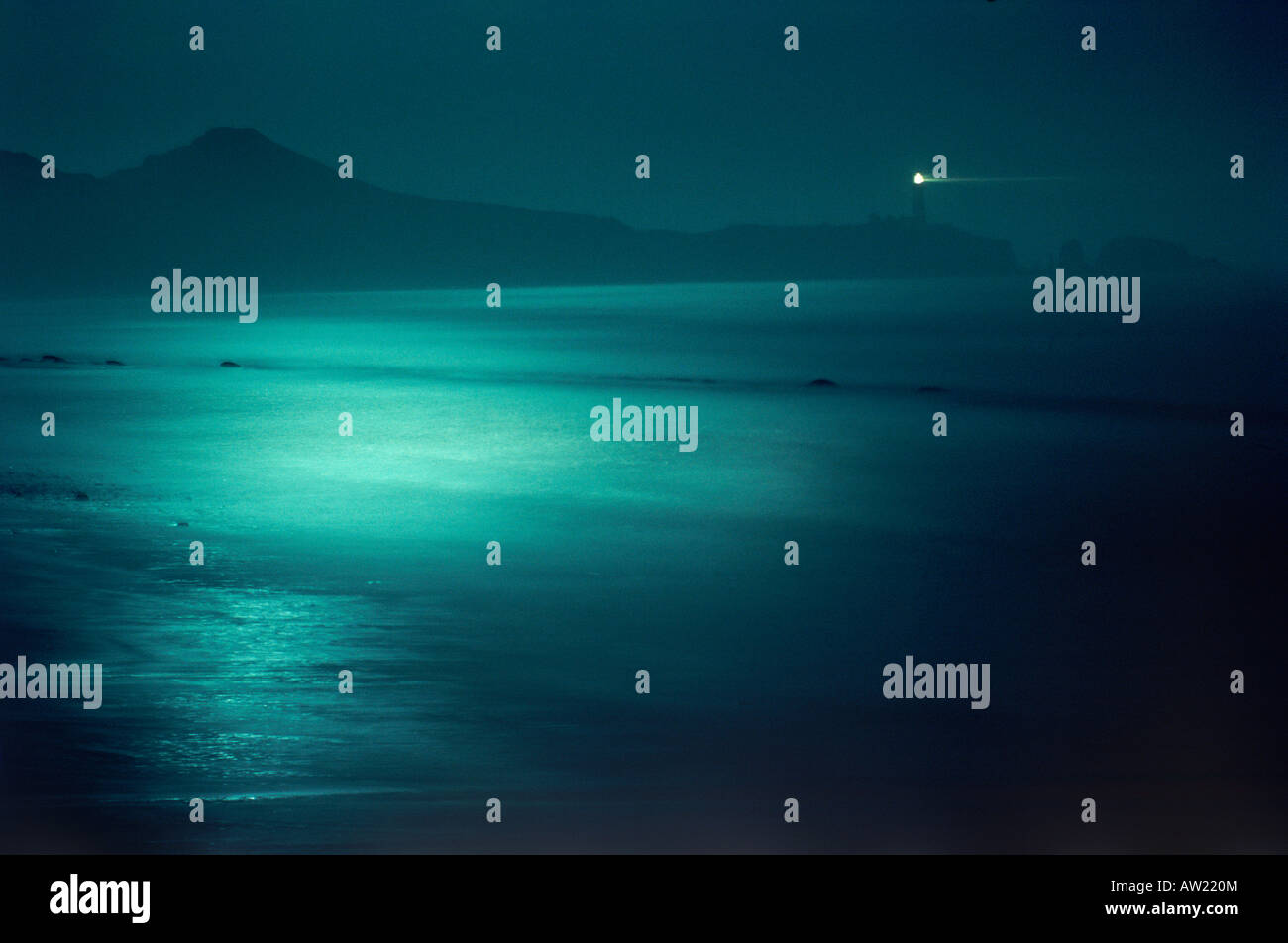 Yaquina Head Lighthouse at night with moonlight reflecting off Pacific Ocean at Newport, Oregon Stock Photo