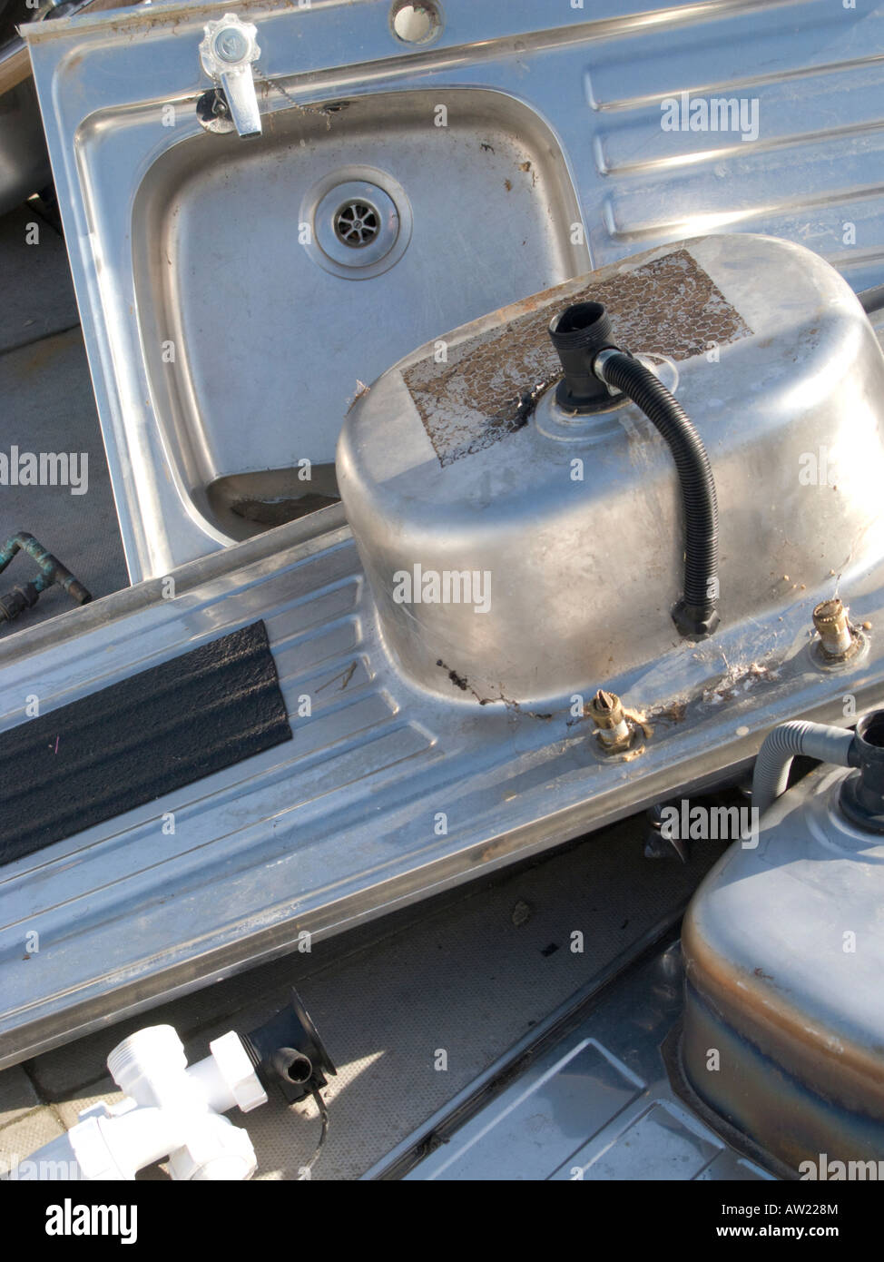 Pile of old stainless steel kitchen sinks in recycling yard awaiting