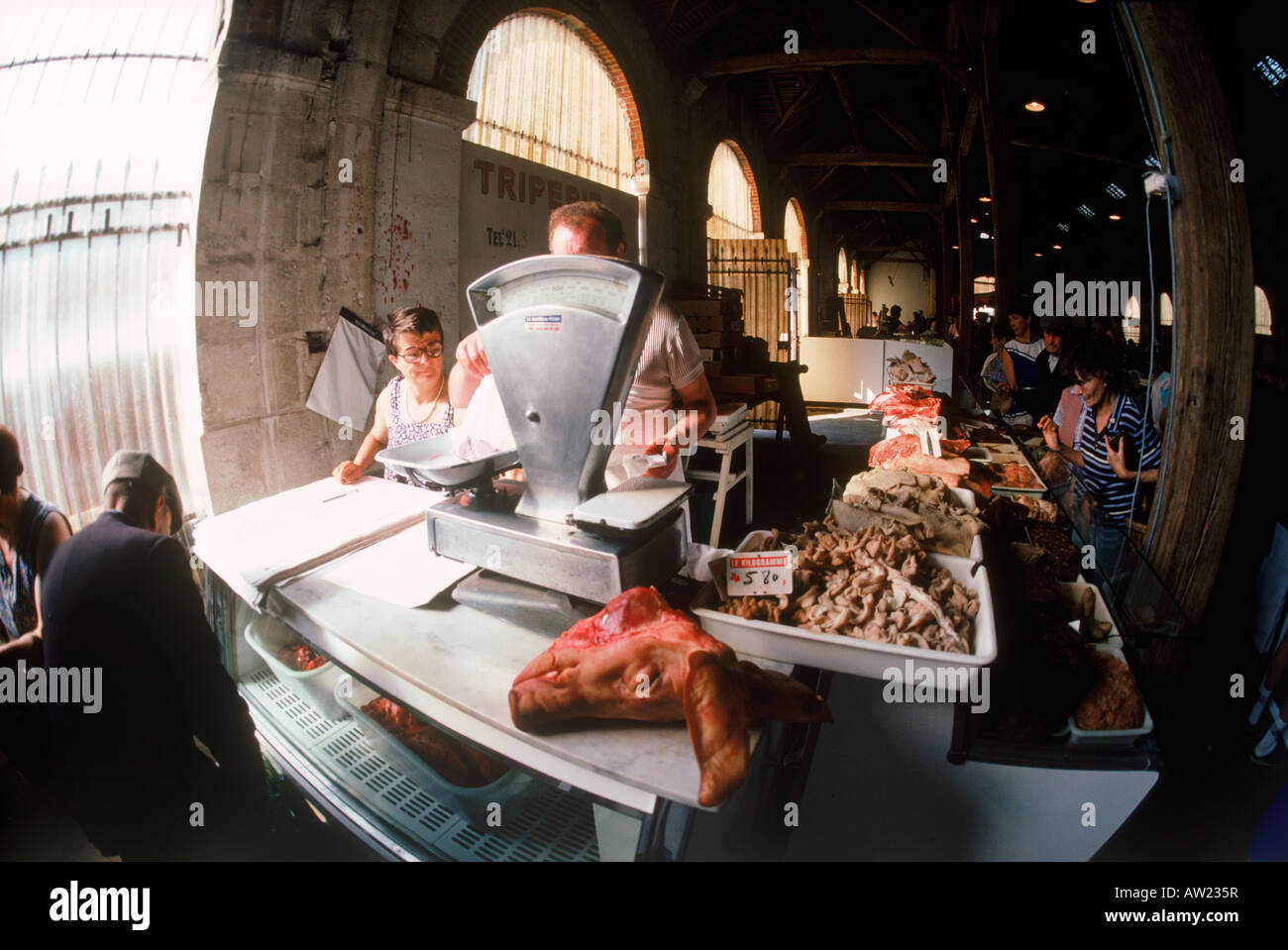 Pigs head with weight scale in open air market with French cheese, vegetables and meats all across France Stock Photo