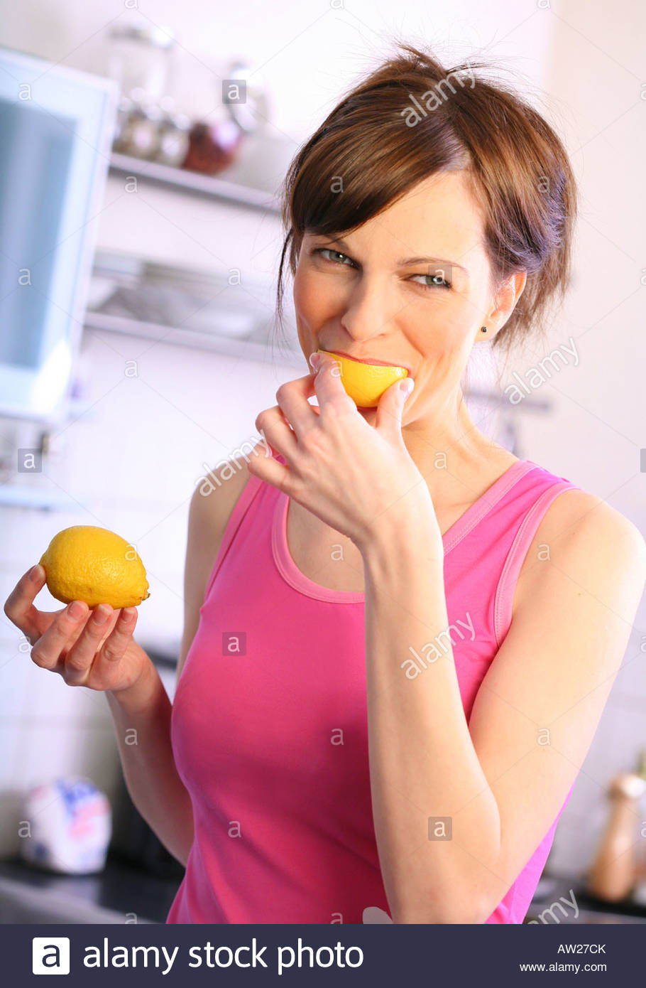 woman eating a lemon Stock Photo