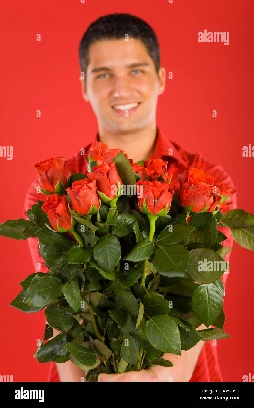 Handsome man in red shirt in strips holding bouquet of roses Smiling ...
