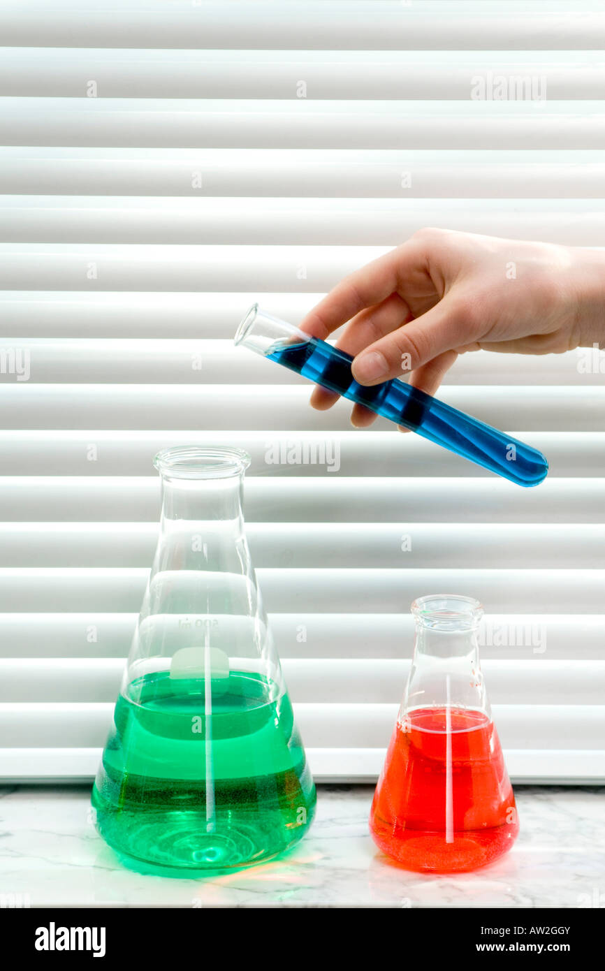 hand pouring liquid into beakers Stock Photo Alamy