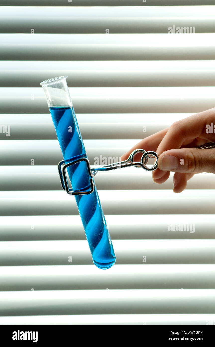 hand holding test tube in tongs Stock Photo Alamy