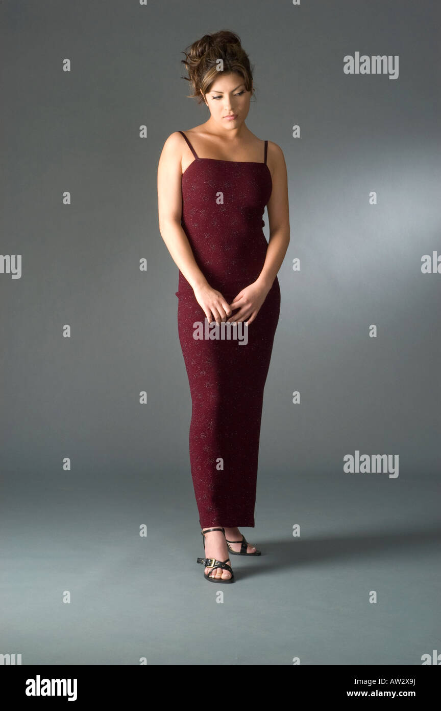sad shy elegantly dress woman in studio full body portrait Stock Photo