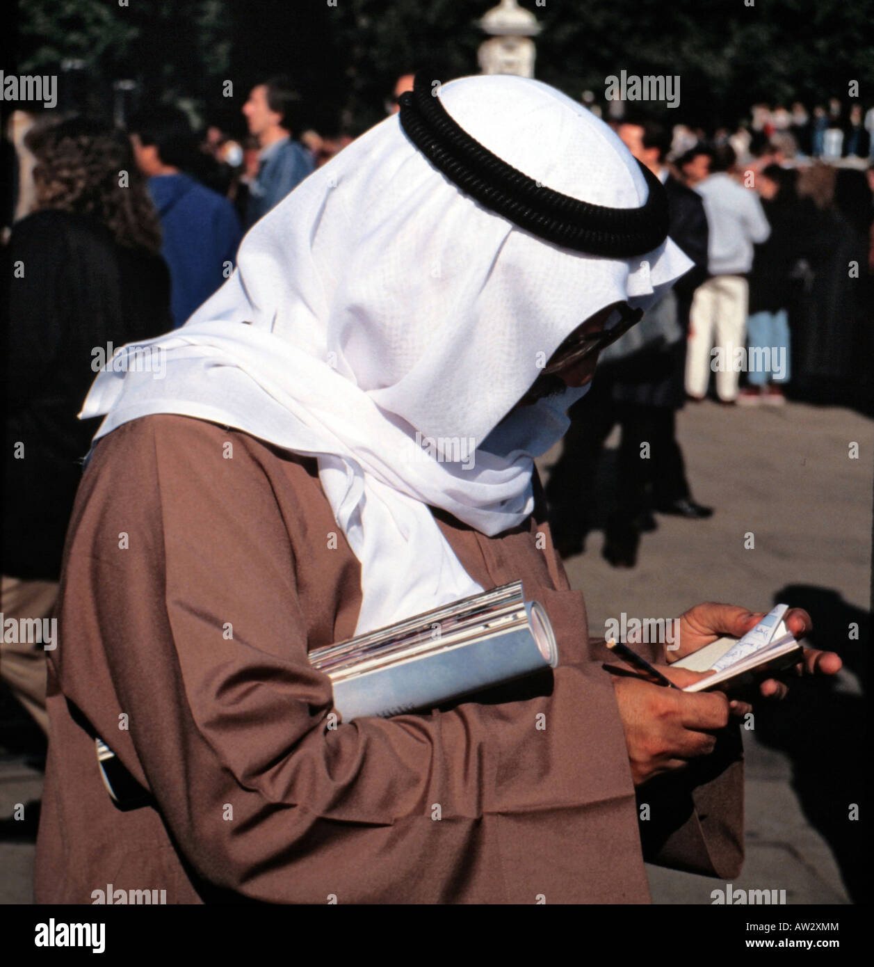 A man wearing a sheik headdress checks his appointment book Stock Photo