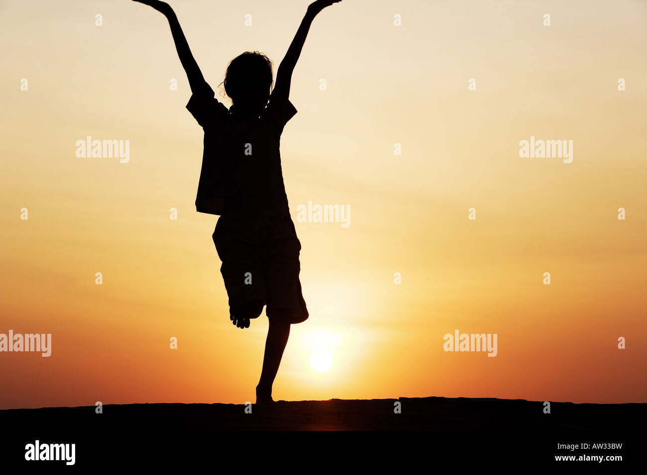 Indian girl silhouette dancing on a rock at sunset. India Stock Photo