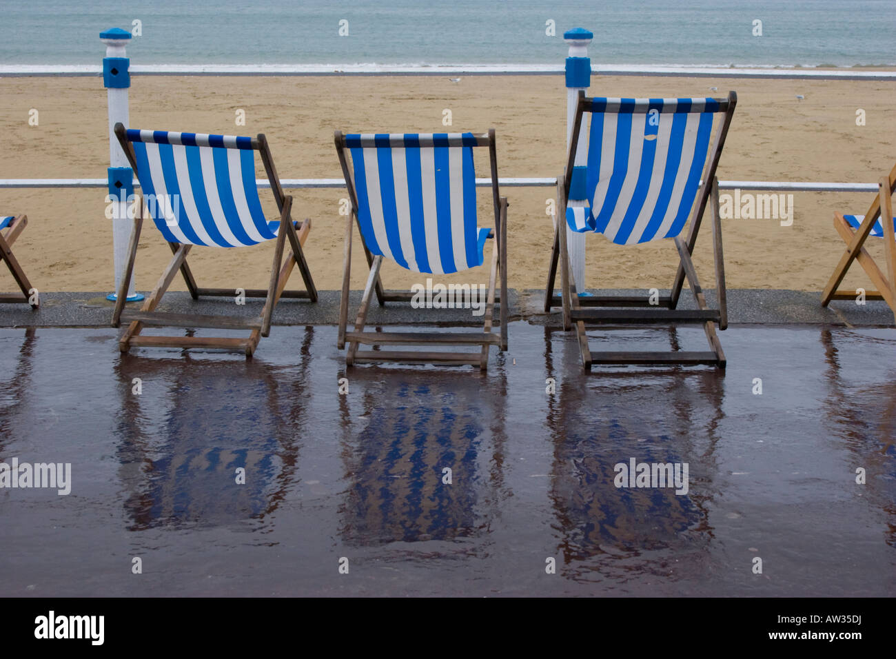 Deck chairs on the seafront during foul wet weather in Weymouth Dorset