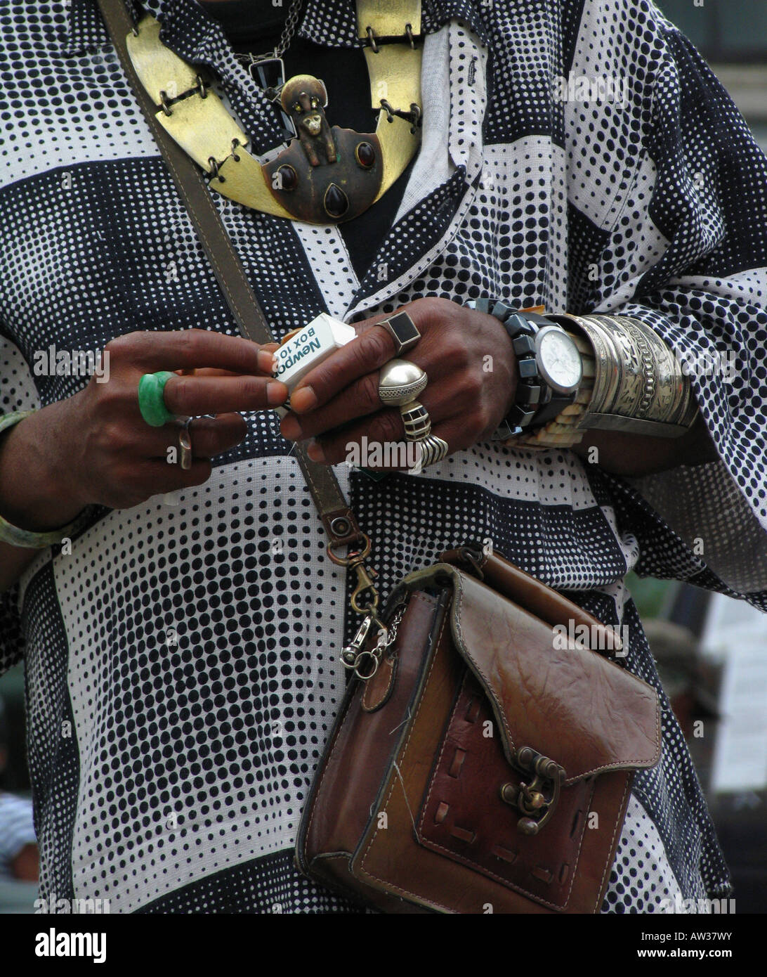 Black man with conspicuous bracelets and other jewelery and leather bag, USA, Harlem, New York Stock Photo