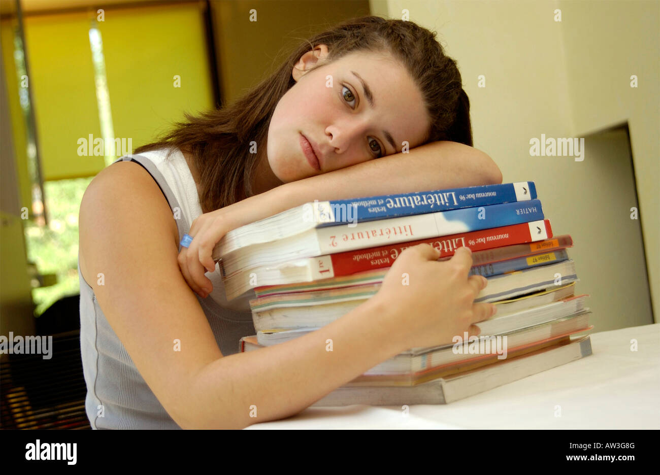 Tired teenage girl student / schoolgirl with her books, exhausted Stock Photo