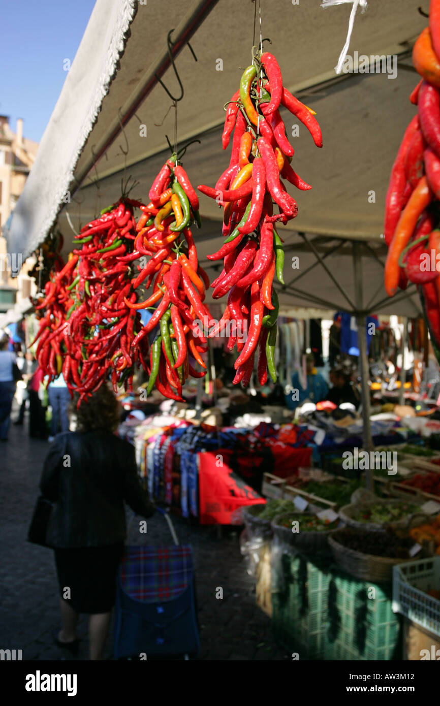Closeup of bright red orange chili peppers hanging up for sale on a ...