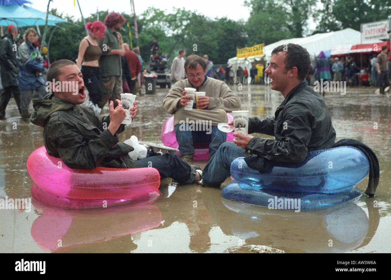 glastonbury 1998 three revelers enjoy cider from the cider bus dispite