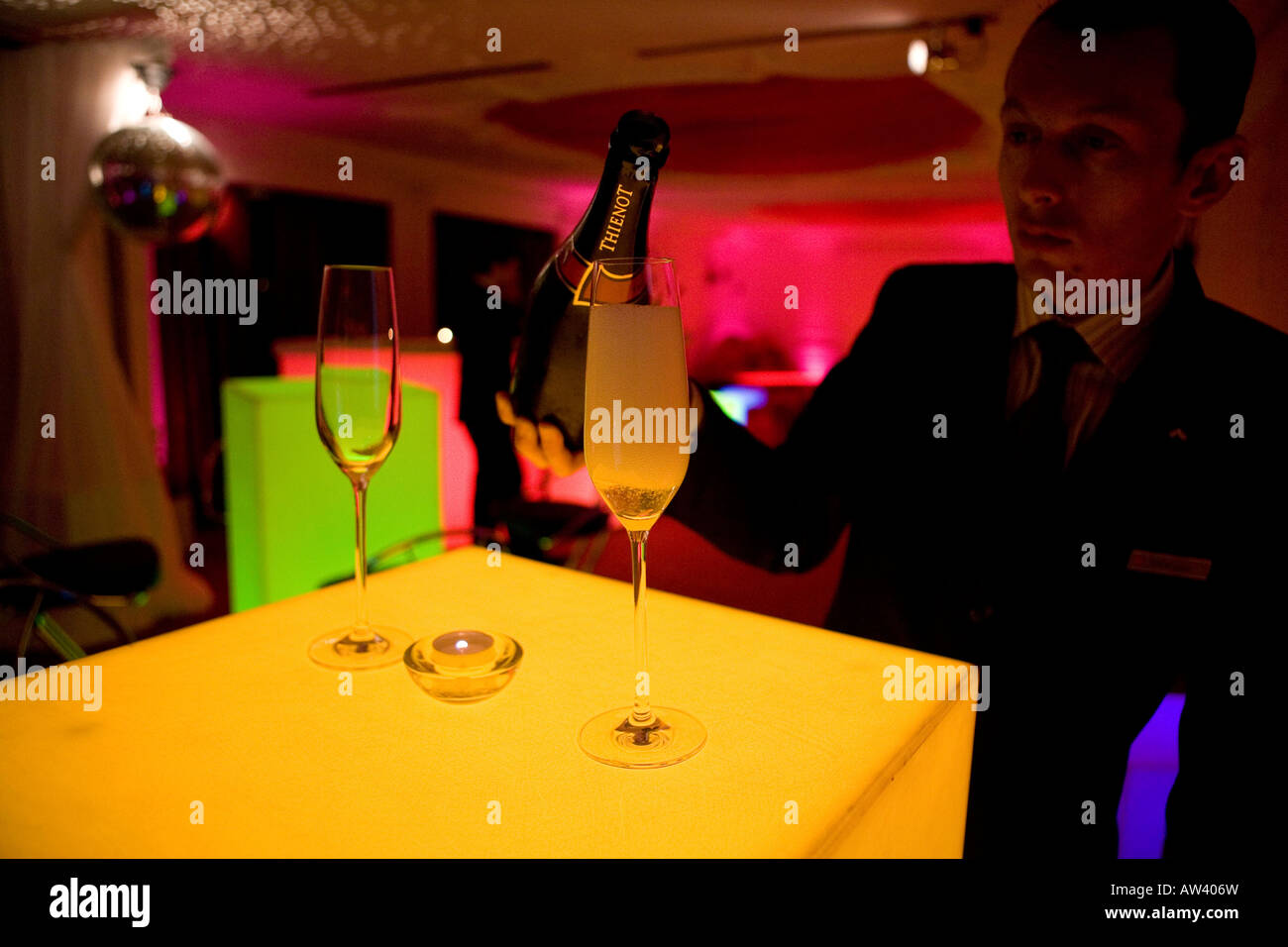 Waiter pouring Champagne in a funky bar Stock Photo