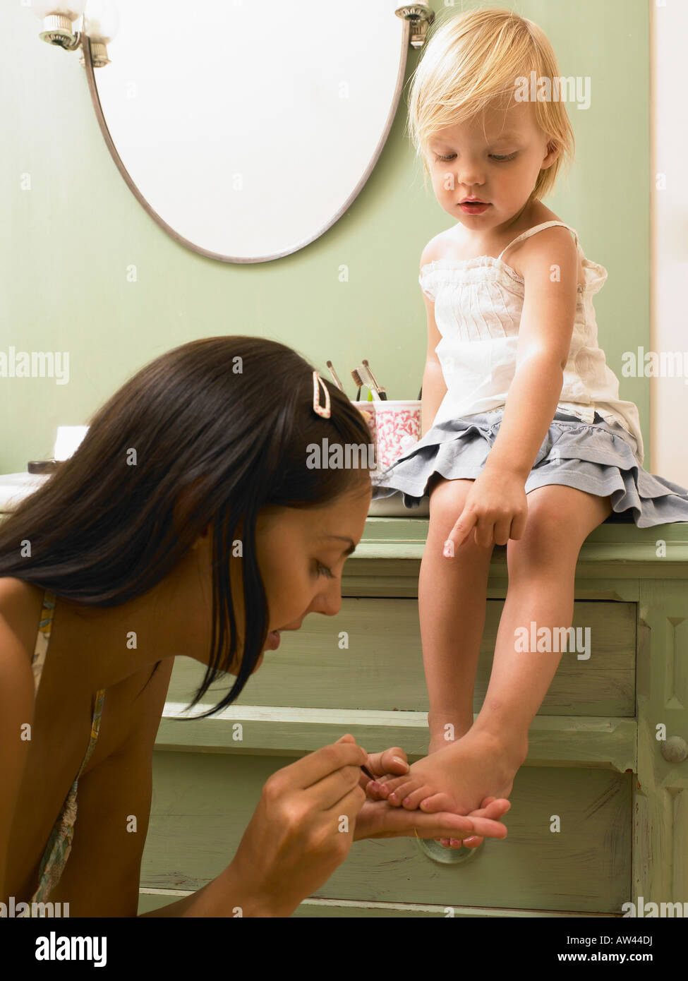 Mother and daughter applying makeup. Stock Photo