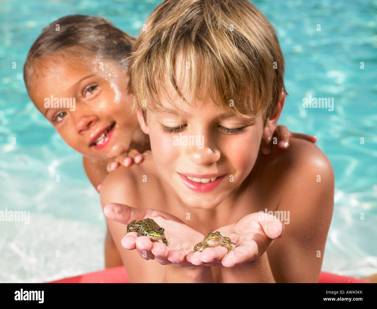 Brother and sister playing with frogs. Stock Photo