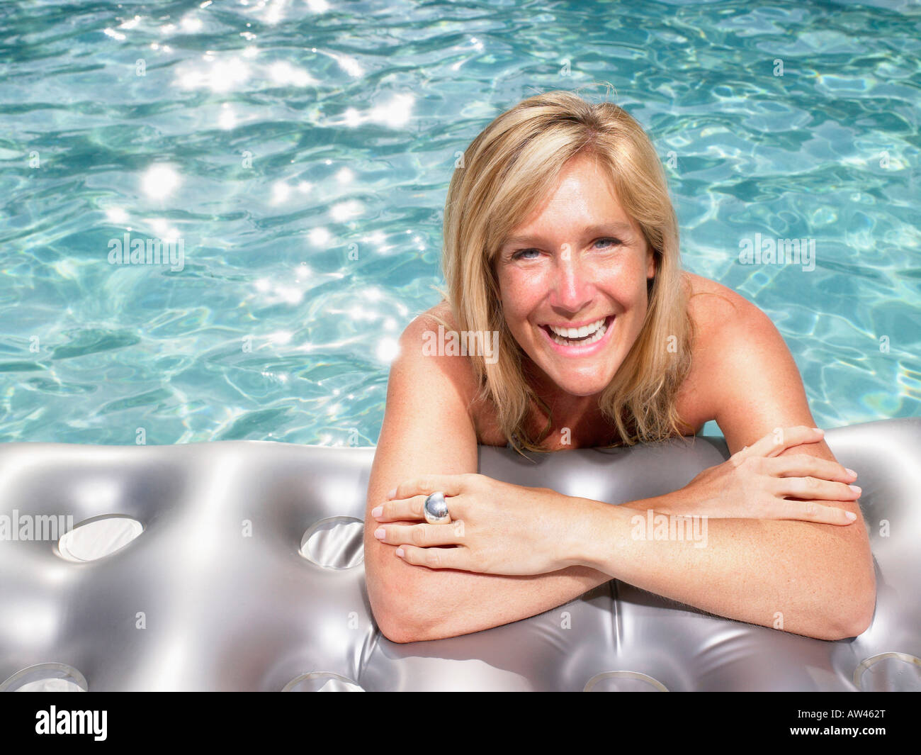 Woman on air mattress in pool. Stock Photo