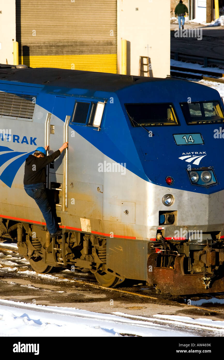 A worker climbs aboard an Amtrak locomotive. Stock Photo