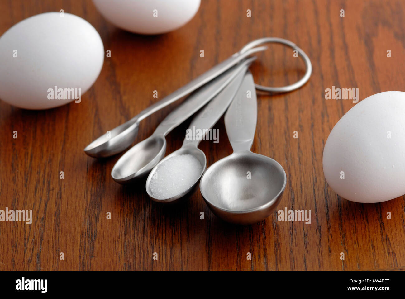 Measuring spoons on a kitchen table Stock Photo - Alamy