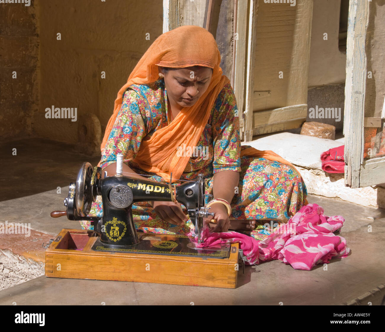 Portrait of a female entrepreneur sewing on an antique sewing machine in India. Stock Photo