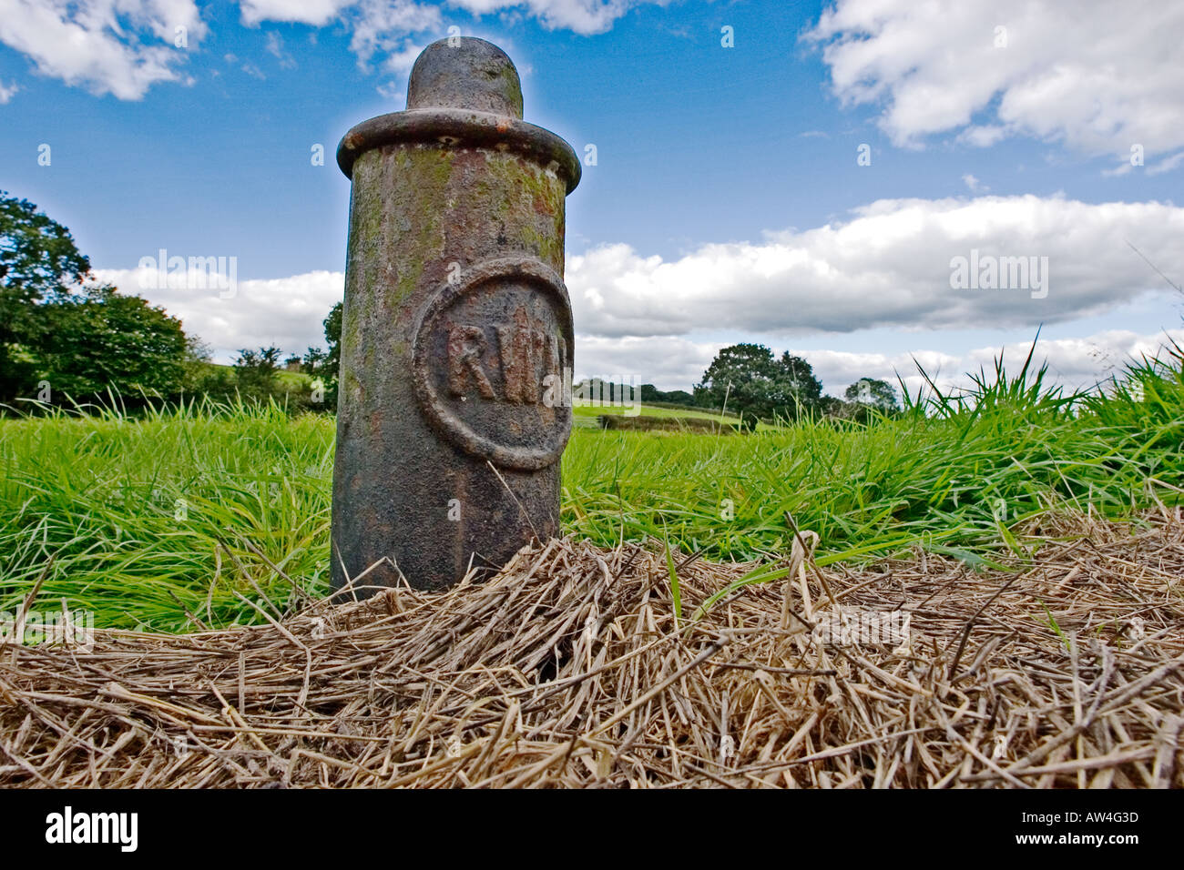 A mooring post belonging to the River Weaver Navigation RWN gradually sinking into the soil next to the River Weaver Stock Photo