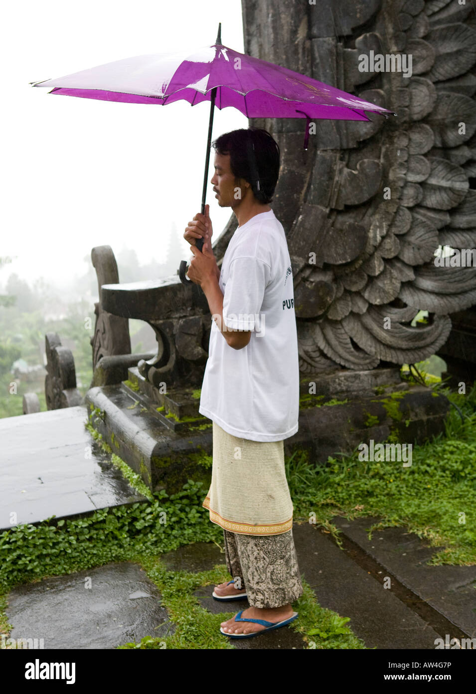 Balinese Man Carrying an Umbrella At The Pura Besakih Temple Bali