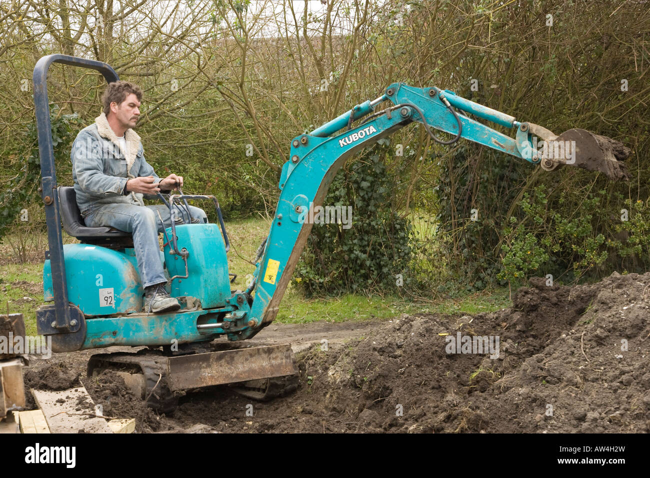 a man driving a mini digger / excavator Stock Photo