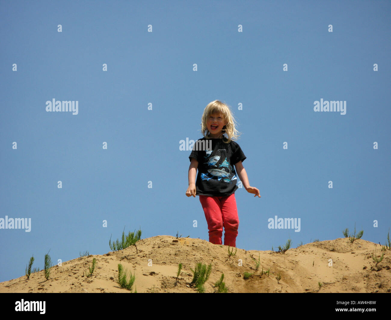 Coos Bay, Oregon, USA Young girl climbing a sand hill Stock Photo