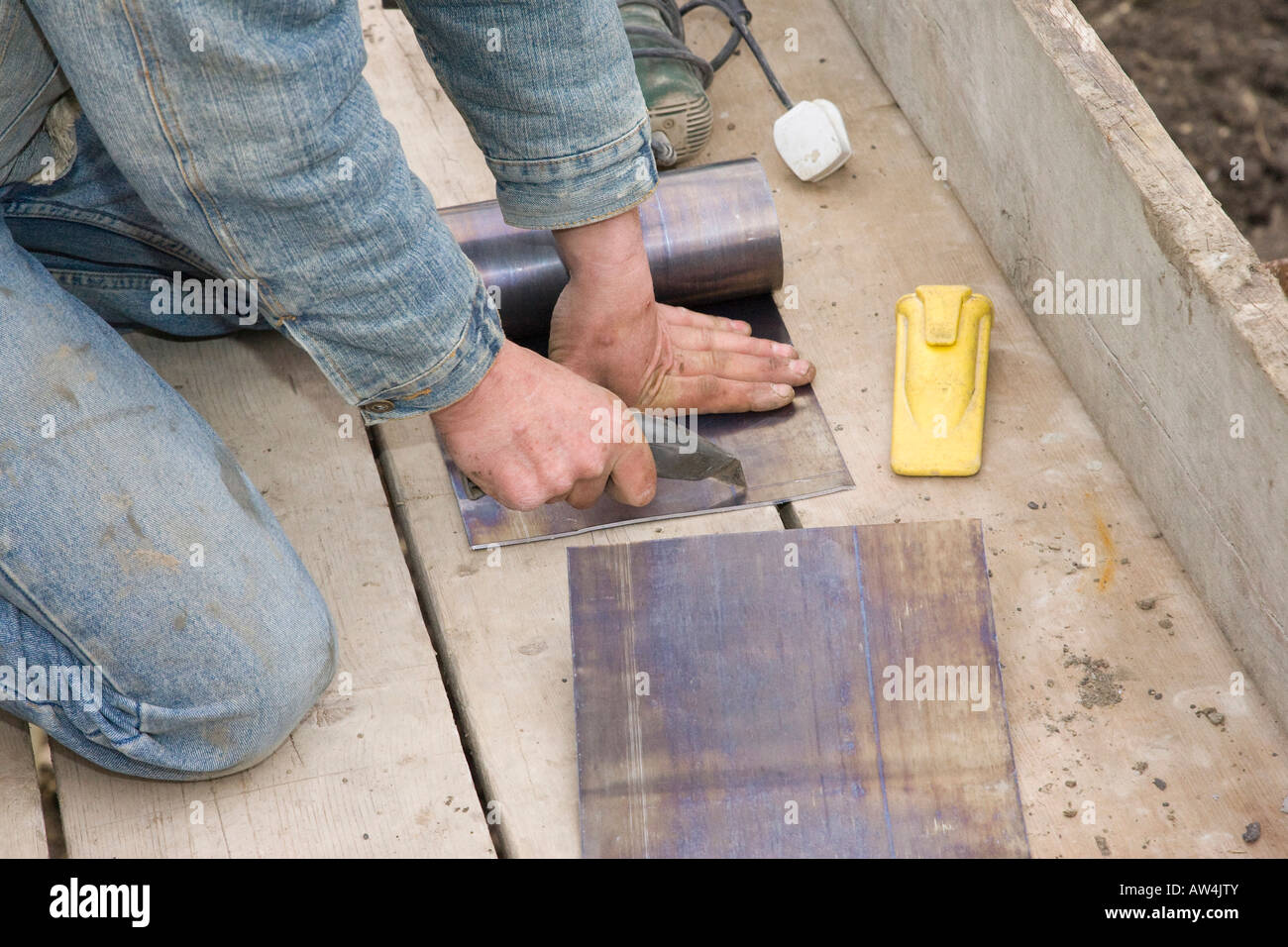 a builder cutting lead flashing with a knife Stock Photo Alamy