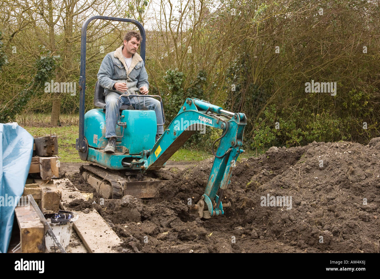 a man driving a mini digger / excavator Stock Photo