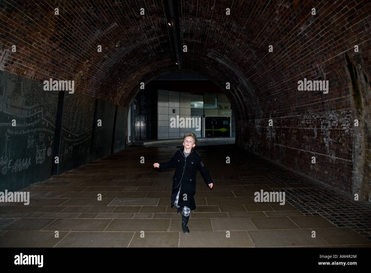 young boy running through dark tunnel in london Stock Photo Alamy